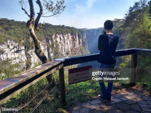 man looking at itaimbezinho canyon, located in aparados da serra national park in cambará do sul, rio grande do sul, brazil. - hill range stock pictures, royalty-free photos & images