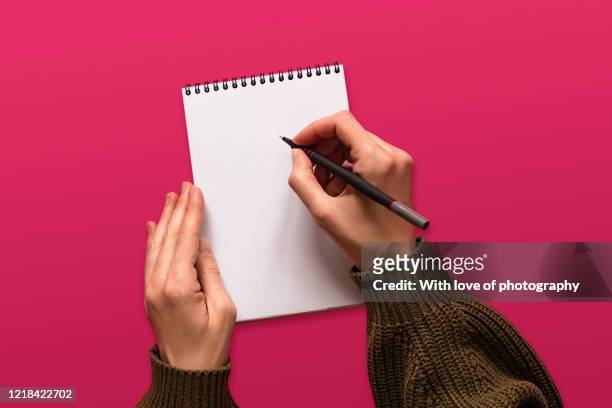creative occupation, creativity, writing in a blank notepad on pink background, hands, goals setting background - escrito à mão imagens e fotografias de stock