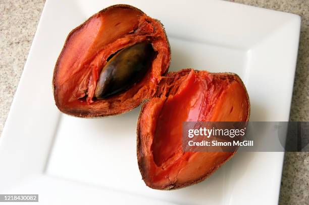 mamey zapote (pouteria sapota) halved on a white plate - chupachupa foto e immagini stock