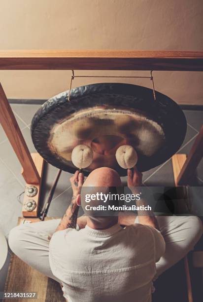 hombre adulto jugando al gong - gong fotografías e imágenes de stock