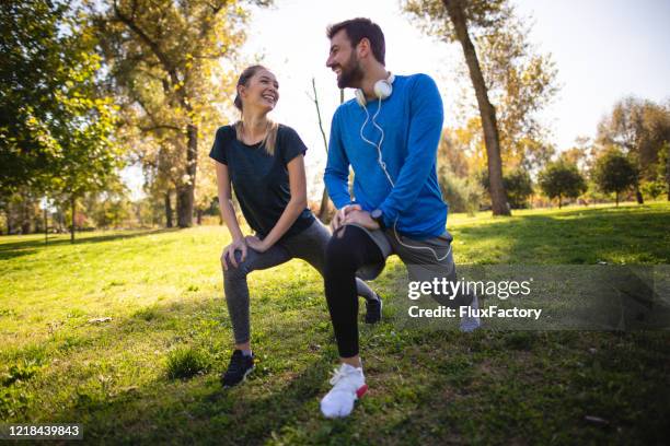 athletic couple stretching outdoors in the park - in the park day 2 stock pictures, royalty-free photos & images