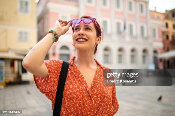 beautiful young woman admiring amazing old city architecture - red dress stock pictures, royalty-free photos & images
