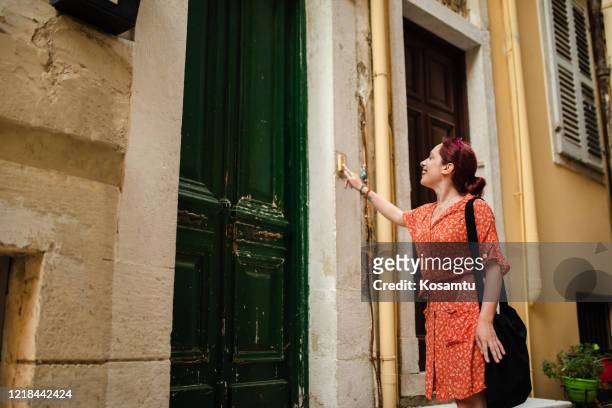 mulher jovem animada toca na porta depois que ela vem para surpreender seu amigo - soar - fotografias e filmes do acervo