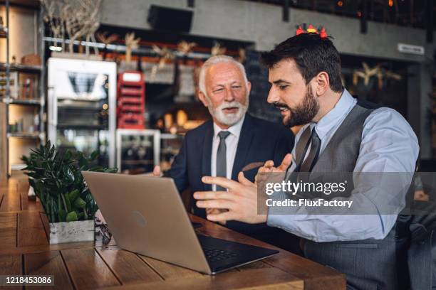 young entrepreneur explaining his business colleague a business plan - orientar imagens e fotografias de stock