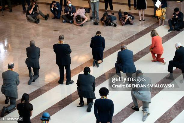 Democratic lawmakers take a knee to observe a moment of silence on Capitol Hill for George Floyd and other victims of police brutality June 8 in...