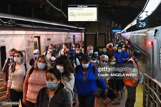 Commuters arrive at Grand Central Station with Metro-North during morning rush hour on June 8, 2020 in New York City. - Today New York City enters...