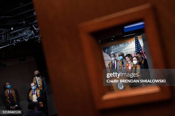 Democrats listen as Speaker of the House Nancy Pelosi speaks during a press conference on Capitol Hill to announce police reform legislation in the...