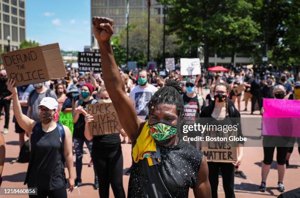 Typhain Hatchoua holds up his fist in solidarity as he joins hundreds of demonstrators who gathered for a "Justice for George Floyd" rally in front...