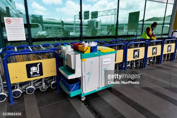 The sanification of the trolleys by a member staff outside the international airport of Roma Leonardo Da Vinci. The airport is slowly come back to...