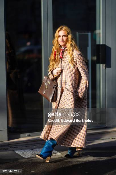 Blanca Miro wears a checked long coat, a red scarf, a brown leather Hermes bag, blue leather boots, outside Lanvin, during Paris Fashion Week -...