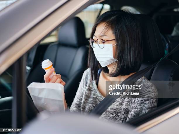 woman wearing mask at drive-through pharmacy - prescription medicine stock pictures, royalty-free photos & images