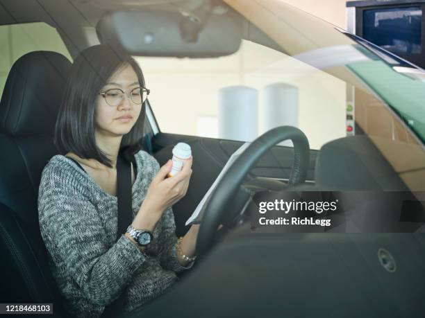 woman at drive-through pharmacy - drive through pharmacy stock pictures, royalty-free photos & images