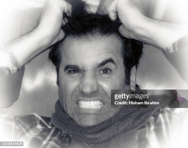 very angry and frustrated man pulling his hair looking stressed. - pulling hair stock pictures, royalty-free photos & images