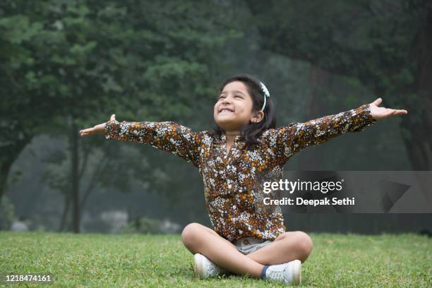 little girl at playground outdoors in summer stock photo - pernas cruzadas imagens e fotografias de stock