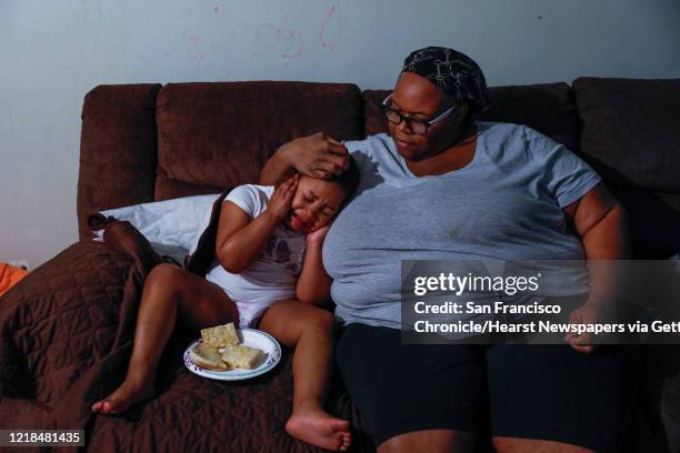 Esther Williams, right, consoles her daughter Miracle Smith who is autistic and was upset by the noise of their new washing machine at their...
