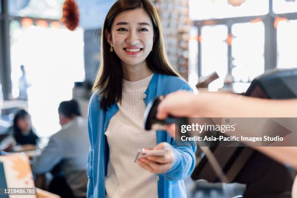 aziatische jonge vrouw die met smartphone in een koffie betaalt. - bar code stockfoto's en -beelden