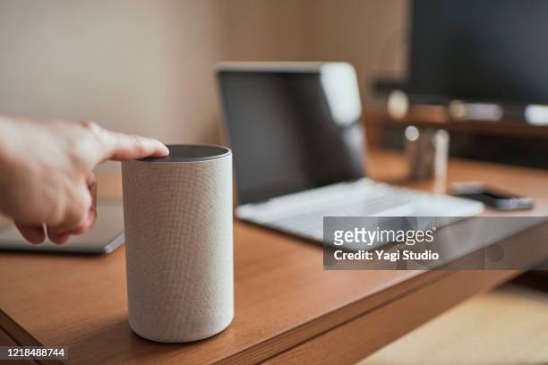 working from home and using a smart speaker - bluetooth foto e immagini stock
