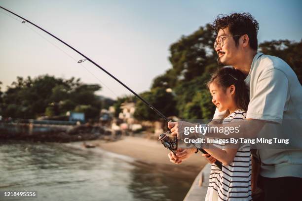 young family fishing together joyfully at pier - fishing ストックフォトと画像