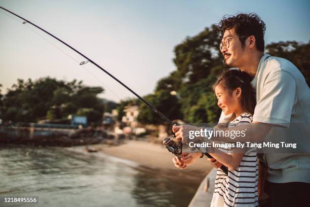 young family fishing together joyfully at pier - kids fishing stock pictures, royalty-free photos & images