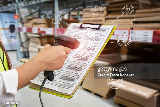 barcode scanner in front of modern warehouse and scanning code on cardboard box - bar code fotografías e imágenes de stock