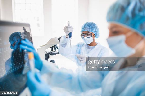 scientists wearing full protective suit working in the laboratory - laboratório imagens e fotografias de stock