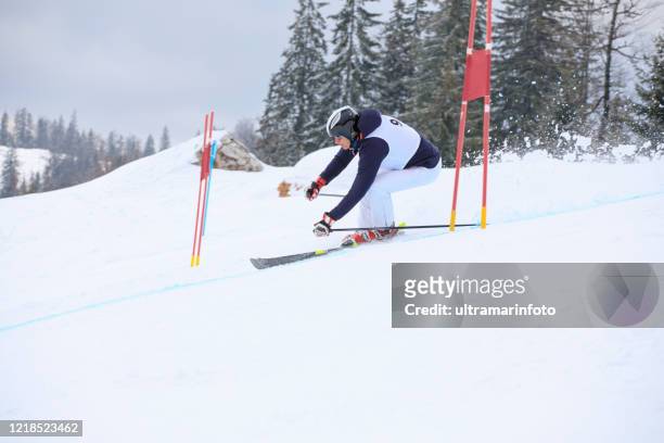 amateur wintersport alpiner ski riesenslalom rennen. senior man schneeskifahrer skifahren im skigebiet. hochgebirgslandschaft - slalom skiing stock-fotos und bilder