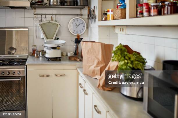 apartment kitchen with grocery bags on counter - kitchen scale stock pictures, royalty-free photos & images