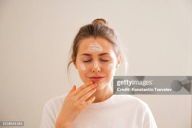 young girl takes care of her face skin. - woman good skin healthy happy stock pictures, royalty-free photos & images