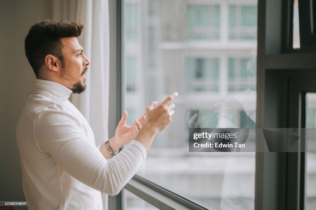 Un hombre del Medio Oriente hablando a la ventana con pantalla digital se muestra practicando la preparación de la presentación