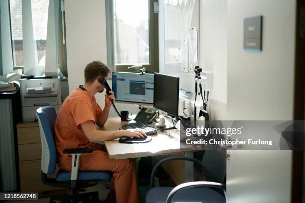 Doctor Judah Eastwell a GP at St Johns Medical Centre, consults a patient via a video link to their home on April 13, 2020 in Altrincham, England. St...