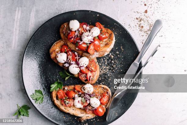tomatoes bruschetta with mozzarella cheese - bruschetta fotografías e imágenes de stock