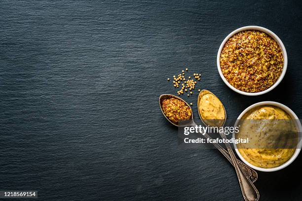 whole grain and dijon mustard shot from above on dark slate background. copy space - dijon mustard stock pictures, royalty-free photos & images