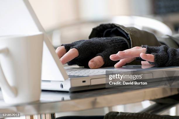 young male using laptop computer keyboard wearing fingerless gloves - fingerless gloves 個照片及圖片檔