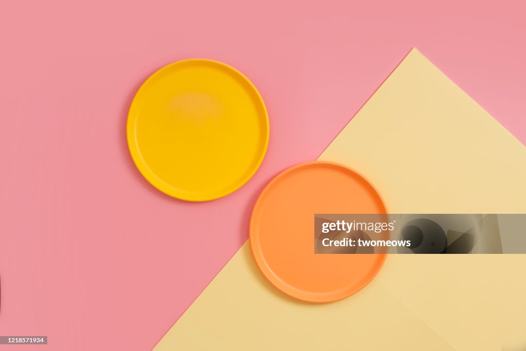 Empty plates on coloured background.