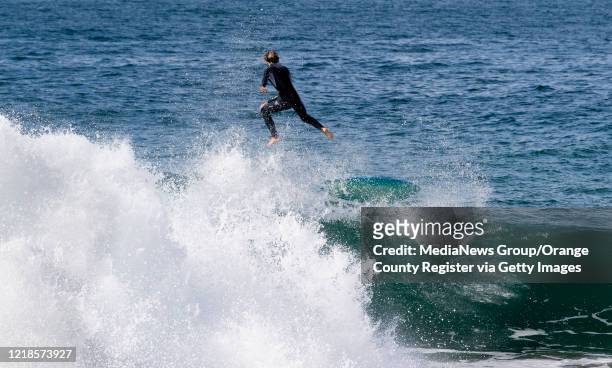 Surfer bails out of a wave at the Wedge in Newport Beach, CA on Friday, April 10, 2020. Officials closed the beach for social distancing concerns and...