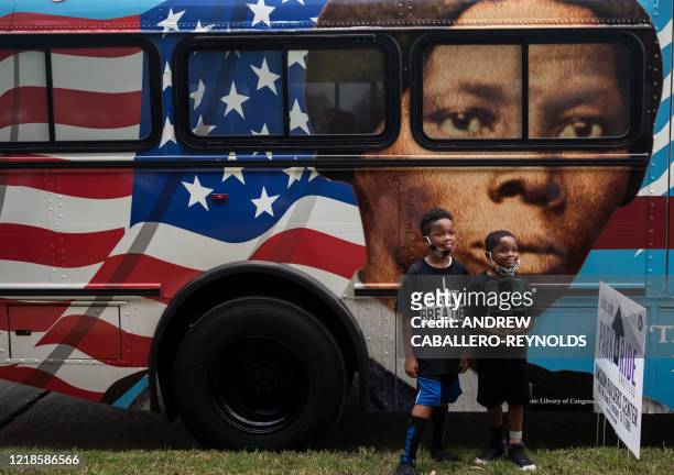 People walk by a bus with a mural of US abolitionist and former slave Harriet Tubman on it, as they arrive to attend the public viewing for George...