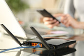 Woman using multiple devices with broadband router on foreground