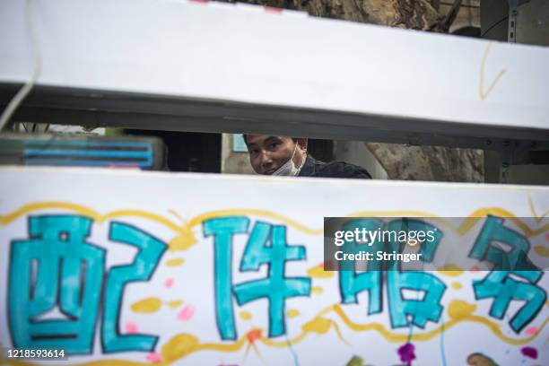 Mobile phone maintenance kiosk is set up in front of a makeshift barricade built to control entry and exit to a residential compound on April 13,...