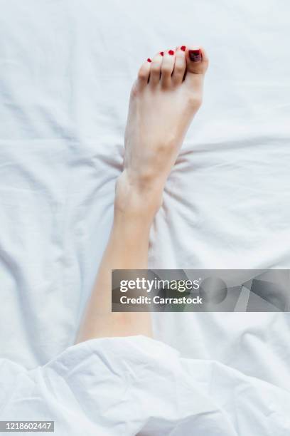 a woman's foot bare in bed. - womans bare feet fotografías e imágenes de stock