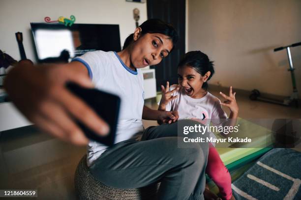 mother and daughter takes selfie during exercising at home - indian child fotografías e imágenes de stock