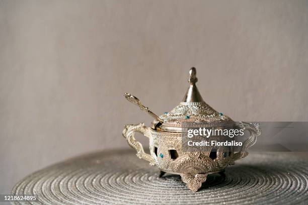 beautiful silver vase with a lid and a teaspoon for oriental-style treats - eid celebration stock pictures, royalty-free photos & images