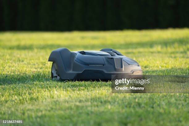 automatische roboter rasenmäher mähgras im garten - rasenmäher stock-fotos und bilder