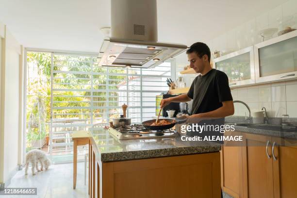 teenager boy cooking - boy cooking stock pictures, royalty-free photos & images