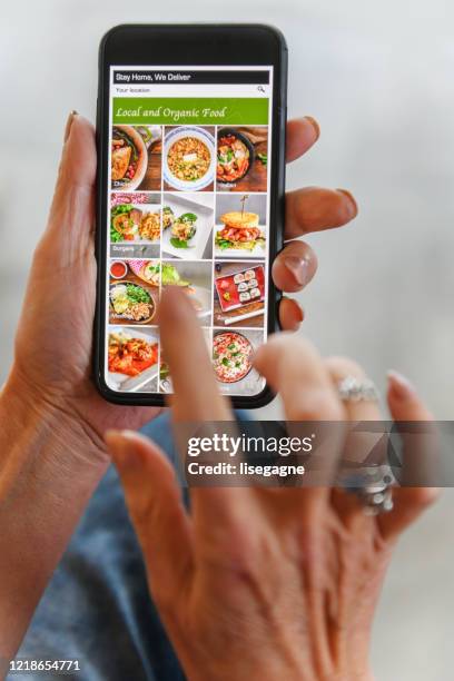 mature woman ordering food online - food delivery service stock pictures, royalty-free photos & images