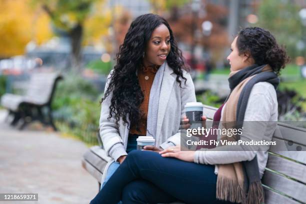 pregnant woman talking with female friend while relaxing on park bench - female with friend in coffee stock pictures, royalty-free photos & images