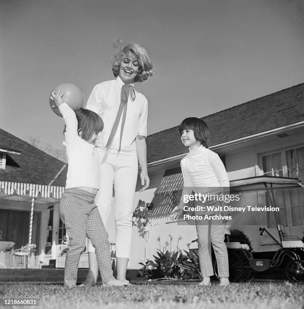 Dorothy Malone and her daughters at home playing, behind the scenes during the making of the ABC tv series 'Peyton Place'.