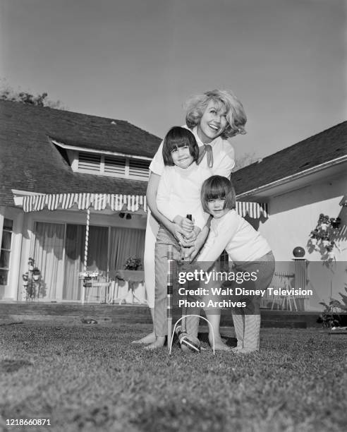 Dorothy Malone and her daughters at home playing croquet, behind the scenes during the making of the ABC tv series 'Peyton Place'.