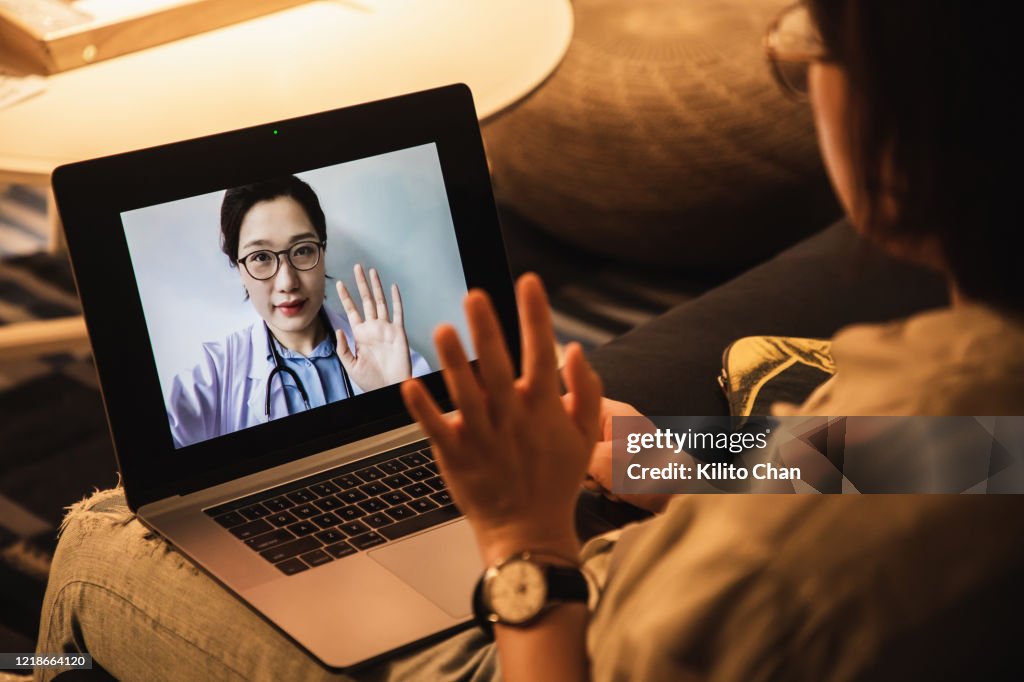 Consulting asian doctors online using laptop