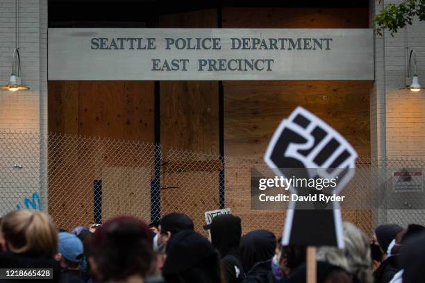 Demonstrators hold a rally and teach-in outside of the Seattle Police Departments East Precinct, which has been boarded up and protected by fencing,...