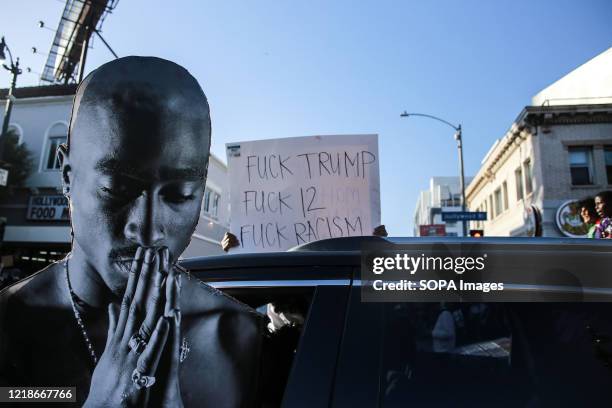 Protester raises a cutout of Tupac Shakur during the demonstration. An estimate of 20,000 protesters gathered in Hollywood to march following the...